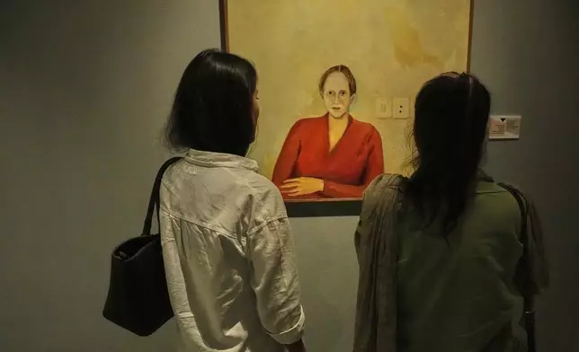 People visit an exhibition called "In Women's Words" showing some artworks of modern Iranian women artists from the collection of the Tehran Museum of Contemporary Art, Iran, Sunday, Aug. 3, 2025. (AP Photo/Vahid Salemi)