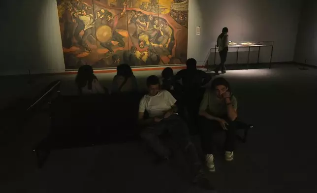 People visit an exhibition called "In Women's Words" showing some artworks of modern Iranian women artists from the collection of the Tehran Museum of Contemporary Art, Iran, Sunday, Aug. 3, 2025. (AP Photo/Vahid Salemi)