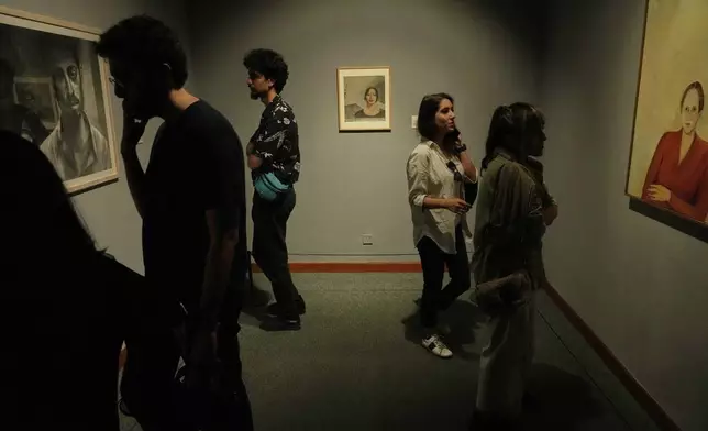 People visit an exhibition called "In Women's Words" showing some artworks of modern Iranian women artists from the collection of the Tehran Museum of Contemporary Art, Iran, Sunday, Aug. 3, 2025. (AP Photo/Vahid Salemi)