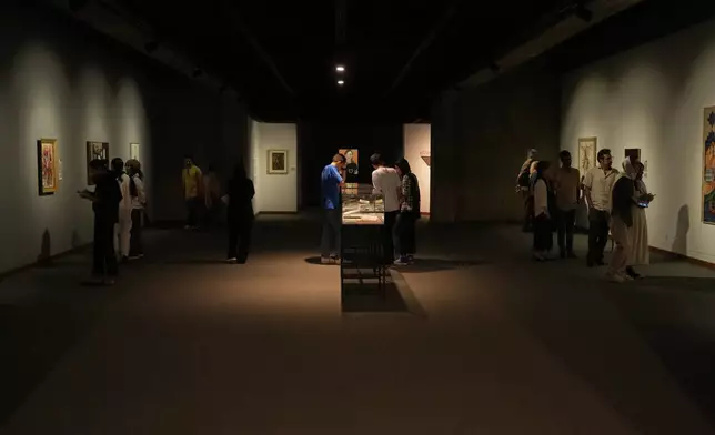 People visit an exhibition called "In Women's Words" showing some artworks of modern Iranian women artists from the collection of the Tehran Museum of Contemporary Art, Iran, Sunday, Aug. 3, 2025. (AP Photo/Vahid Salemi)