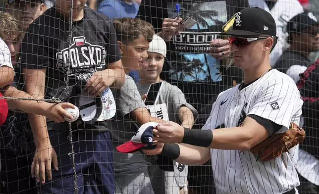 Chicago White Sox's Colson Montgomery gives an autograph before a baseball game against the Minnesota Twins in Chicago, Sunday, Aug. 24, 2025. (AP Photo/Nam Y. Huh)