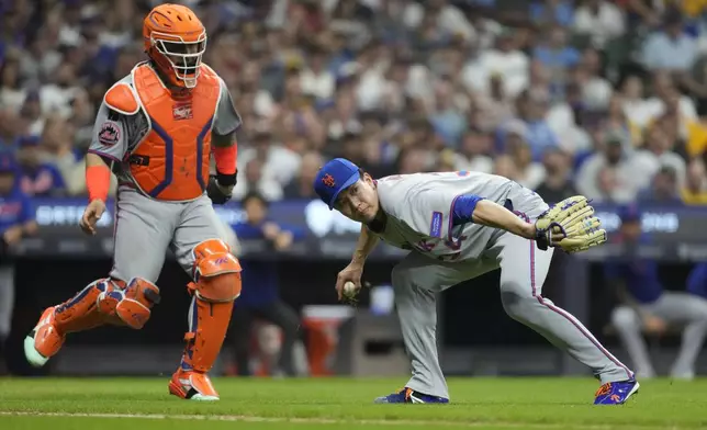 New York Mets' Kodai Senga looks to first base after fielding a ball hit in the infield during the fifth inning of a baseball game against the Milwaukee Brewers, Friday, Aug. 8, 2025, in Milwaukee. (AP Photo/Aaron Gash)