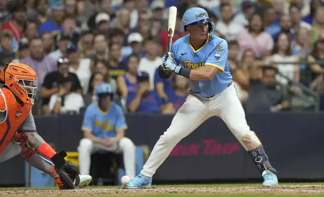 Milwaukee Brewers' Isaac Collins, right, is hit by a pitch with the bases loaded to drive in a run during the fifth inning of a baseball game against the New York Mets, Friday, Aug. 8, 2025, in Milwaukee. (AP Photo/Aaron Gash)