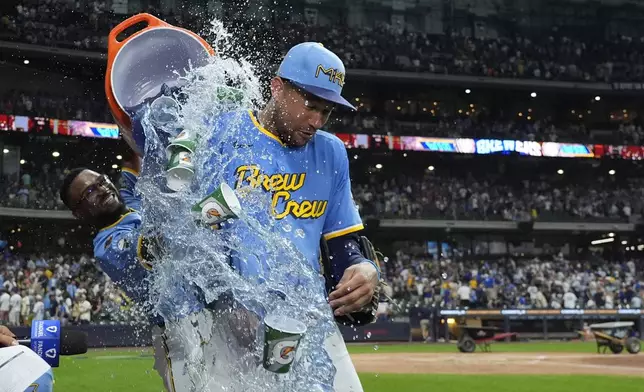 Milwaukee Brewers' Blake Perkins, right, is doused by Andruw Monasterio, left, after a baseball game against the New York Mets, Friday, Aug. 8, 2025, in Milwaukee. (AP Photo/Aaron Gash)
