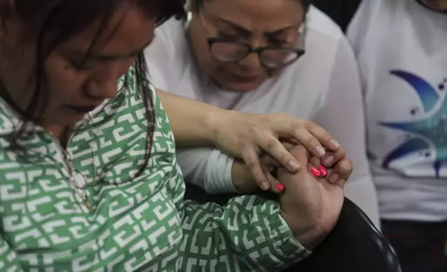 People pray prior to a hearing for seven people accused of responsibility for a fire at a government-run facility for at-risk girls that killed 41 girls in 2017, in Guatemala City, Tuesday, Aug. 12, 2025. (AP Photo/Moises Castillo)