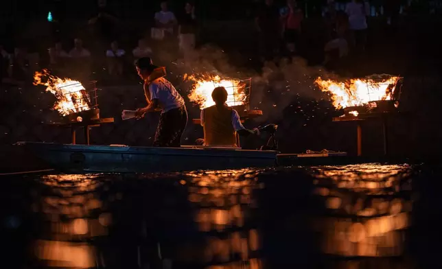 Bonfires are lit along the Motoyasu River in front of the Atomic Bomb Dome during a remembrance ceremony in Hiroshima, Tuesday, Aug. 5, 2025 on the eve of the 80th anniversary of the atomic bombing. (AP Photo/Louise Delmotte)