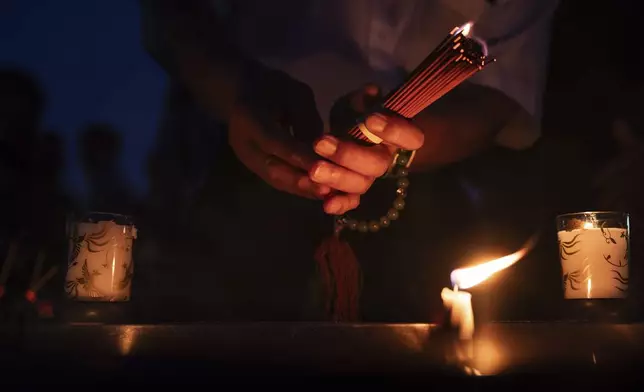 Visitors light incense sticks and pray at the Peace Memorial Park ahead of the memorial service to mark the 80th anniversary of the WWII U.S. atomic bombing in Hiroshima, Wednesday, Aug. 6, 2025, in Japan. (AP Photo/Louise Delmotte)