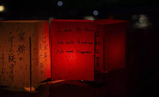 Paper lanterns float along the Motoyasu river in front of the Atomic Bomb Dome on the 80th anniversary of the WWII U.S. atomic bombing in Hiroshima, Wednesday, Aug. 6, 2025. (AP Photo/Louise Delmotte)
