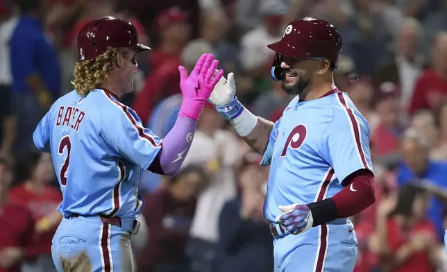 Philadelphia Phillies' Kyle Schwarber, right, and Harrison Bader celebrate after Schwarber's three-run home run during the fifth inning of a baseball game against the Atlanta Braves Thursday, Aug. 28, 2025, in Philadelphia. (AP Photo/Matt Slocum)