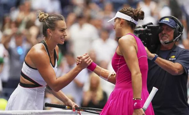 Aryna Sabalenka, of Belarus, shakes hands with Rebeka Masarova, of Switzerland, after winning their first-round match of the US Open tennis championships, Sunday, Aug. 24, 2025, in New York. (AP Photo/Kirsty Wigglesworth)