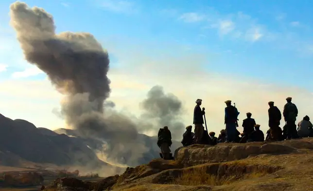 FILE - In this Nov. 19, 2001 file photo, Northern Alliance soldiers watch as U.S. air strikes attack Taliban positions in Kunduz province, Afghanistan. (AP Photo/Ivan Sekretarev, File)