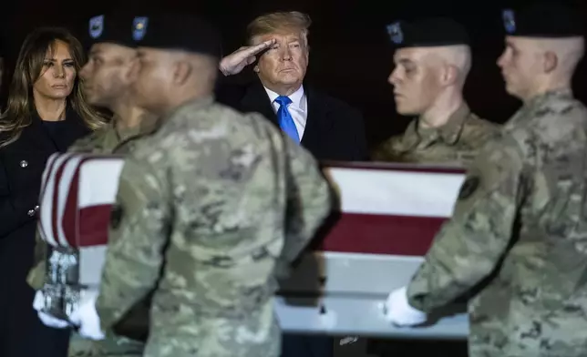 FILE - President Donald Trump and first lady Melania Trump watch as a U.S. Army carry team moves a transfer case containing the remains of Chief Warrant Officer 2 David C. Knadle, of Tarrant, Texas, Nov. 21, 2019, at Dover Air Force Base, Del. (AP Photo/Matt Rourke, file)