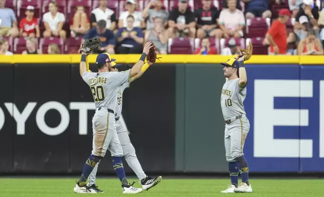 From left, Milwaukee Brewers' Brandon Lockridge, Stewart Berroa and Sal Frelick celebrate their win at the conclusion of a baseball game against the Cincinnati Reds, Friday, Aug. 15, 2025, in Cincinnati. (AP Photo/Kareem Elgazzar)
