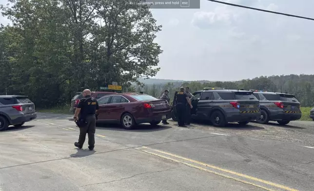This image provided by WNEP shows police near the scene of a shooting where two state troopers were injured, Thursday, Aug. 7, 2025 near the village of Thompson in Susquehanna County, Pa. (WNEP via AP)