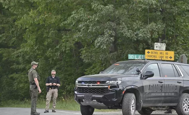 Police officers block the street leading to where two Pennsylvania state troopers were ambushed and shot Thursday, Aug. 7, 2025, near the village of Thompson in Susquehanna County, Pa. (AP Photo/Aimee Dilger)