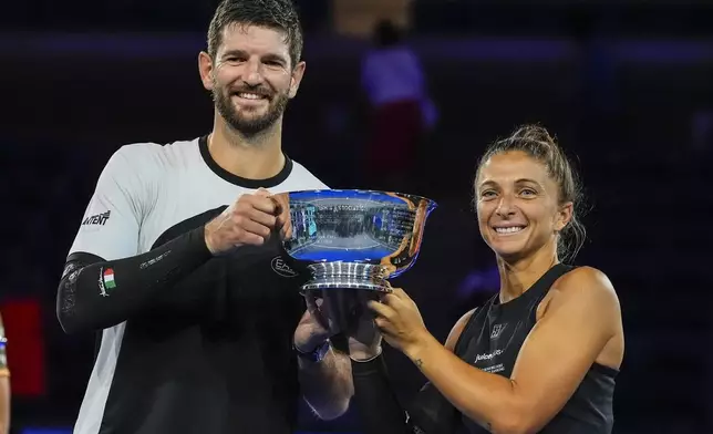 Andrea Vavassori, left, of Italy, and Sara Errani, of Italy, hold up the championship trophy after defeating Iga Swiatek, of Poland, and Casper Ruud, of Norway, in the mixed doubles final at the U.S. Open tennis championships, Wednesday, Aug. 20, 2025, in New York. (AP Photo/Yuki Iwamura)