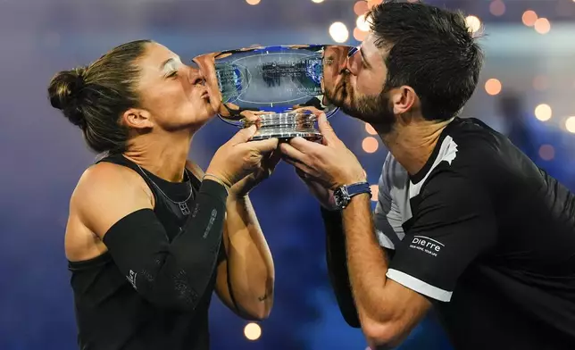 Andrea Vavassori, right, of Italy, and Sara Errani, left, of Italy, hold up the championship trophy after defeating Iga Swiatek, of Poland, and Casper Ruud, of Norway, in the mixed doubles final at the U.S. Open tennis championships, Wednesday, Aug. 20, 2025, in New York. (AP Photo/Yuki Iwamura)