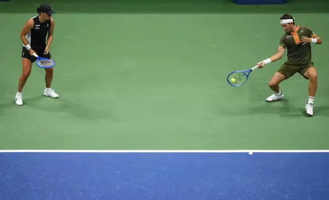 Casper Ruud, right, of Norway, plays with Iga Swiatek, left, of Poland, during the mixed doubles semi final at the U.S. Open tennis championships, Wednesday, Aug. 20, 2025, in New York. (AP Photo/Yuki Iwamura)