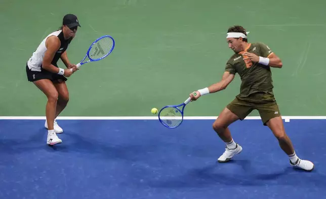 Casper Ruud, right, of Norway, plays with Iga Swiatek, left, of Poland, during the mixed doubles final at the U.S. Open tennis championships, Wednesday, Aug. 20, 2025, in New York. (AP Photo/Yuki Iwamura)