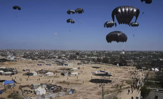 Palestinians rush to collect humanitarian aid airdropped in central Gaza Strip, Thursday, July 31, 2025. (AP Photo/Abdel Kareem Hana)