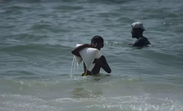 FILE - A Palestinian youth carries a sack of aid that landed in the Mediterranean Sea after being airdropped over central Gaza, Gaza Strip Tuesday, July 29, 2025. (AP Photo/Abdel Kareem Hana, File)