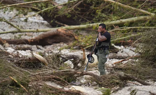 FILE - A sheriff's deputy pauses while combing through debris on the banks of the Guadalupe River near Camp Mystic in Hunt, Texas, on July 5, 2025, after a deadly flash flood swept through the area. (AP Photo/Julio Cortez, file)