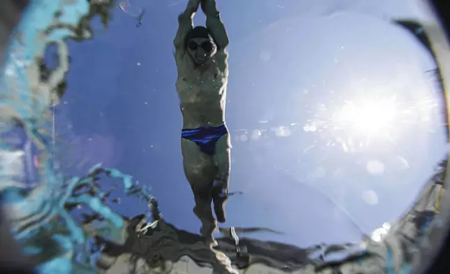 Ukrainian war veteran Pavlo Tovstyk jumps in a pool in Kyiv, Ukraine, Saturday, Aug. 16, 2025, during a training session to compete in a 6.5km swimming race across the Bosporus Strait. (AP Photo/Evgeniy Maloletka)