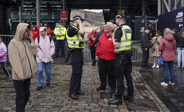 Members of the public are turned away from Edinburgh Castle as the site is closed to visitors due to high winds, in Scotland, Monday Aug. 4, 2025, as weather warnings are coming into force with Storm Floris expected to cause severe travel disruption to road, air and ferry services, and close bridges. (Jane Barlow/PA via AP)
