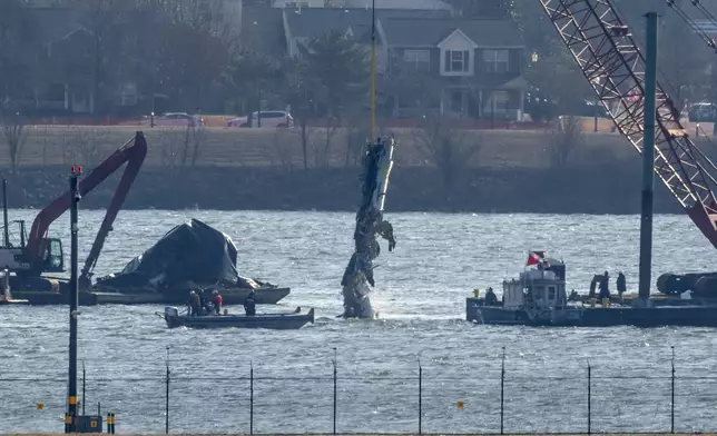 FILE - A piece of wreckage is lifted from the water onto a salvage vessel near the site in the Potomac River of a mid-air collision between an American Airlines jet and a Black Hawk helicopter, at Ronald Reagan Washington National Airport, Feb. 4, 2025, in Arlington, Va. (AP Photo/Ben Curtis, file)
