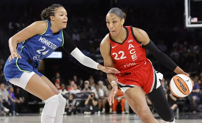 Las Vegas Aces center A'ja Wilson (22) drives against Minnesota Lynx forward Napheesa Collier (24) during the first half of a WNBA basketball game Saturday, Aug. 2, 2025, in Las Vegas. (Steve Marcus/Las Vegas Sun via AP)