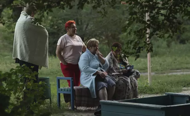 Local residents look at their destroyed home following Russian air strike in Zaporizhzhia, Ukraine, Saturday, Aug. 30, 2025. (AP Photo/Kateryna Klochko)