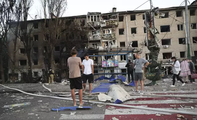 Local residents stand near their destroyed home following Russian air strike in Zaporizhzhia, Ukraine, Saturday, Aug. 30, 2025. (AP Photo/Kateryna Klochko)