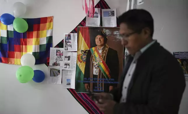 Guido Ramirez, supporters of former President Evo Morales, stands near a poster of Morales at a campaign center for Morales supporters who are in favor of a null vote in the upcoming presidential election in El Alto, Bolivia, Tuesday, Aug. 12, 2025. (AP Photo/Natacha Pisarenko)