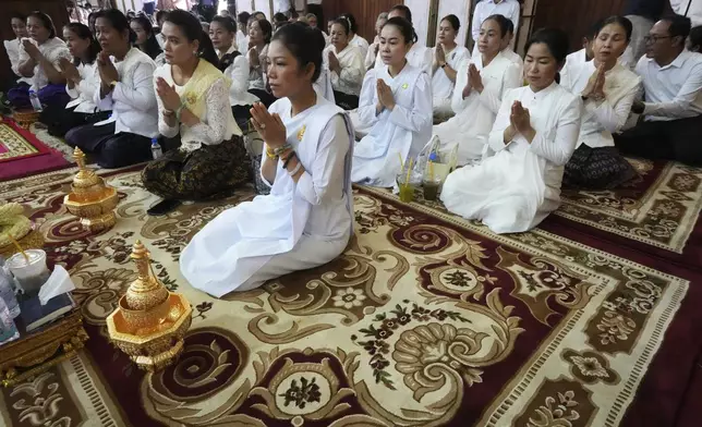 Cambodian Buddhist followers offer prayers to the remains of the soldiers who sacrificed their lives in battles with Thai troops along the disputed border areas, at a Buddhist pagoda of Wat Botumvotey in Phnom Penh, Cambodia, Friday, Aug. 8, 2025. (AP Photo/Heng Sinith)