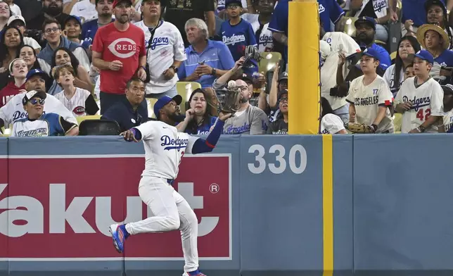 Los Angeles Dodgers right fielder Teoscar Hernandez makes the catch at the wall for the out on Cincinnati Reds' Ke'Bryan Hayes during the second inning of a baseball game Monday, Aug. 25, 2025, in Los Angeles. (AP Photo/Jayne Kamin-Oncea)