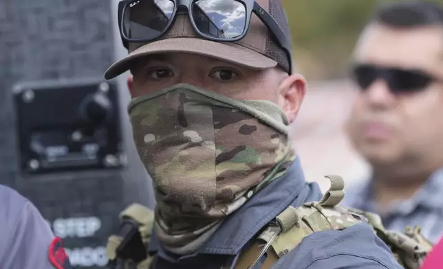 A federal agent escorts a man to a bus after he was detained following an appearance at immigration court, Monday, July 28, 2025, in San Antonio. (AP Photo/Eric Gay)