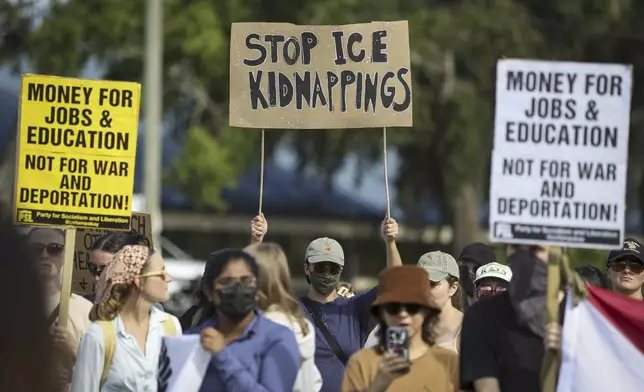 FILE - Demonstrators hold signs during an immigration rally near the Pinellas County Jail in Clearwater, Fla., on Saturday, June 14, 2025. (Chris Urso/Tampa Bay Times via AP, File)