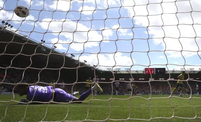 Wrexham's Josh Windass scores his side's first goal of the game from the penalty spot past Southampton goalkeeper Gavin Bazunu during their English Football League Championship soccer match, at St Mary's Stadium, Southampton, England, Saturday, Aug. 9, 2025. (Steven Paston/PA via AP)