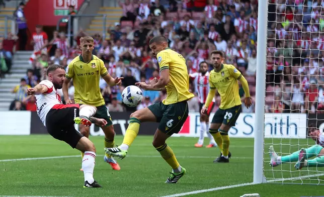 Southampton's Adam Armstrong, left, attempts a shot towards goal but is blocked by Wrexham's Conor Coady during their English Football League Championship match at St Mary's Stadium, Southampton, England, Saturday, Aug. 9, 2025. (Steven Paston/PA via AP)
