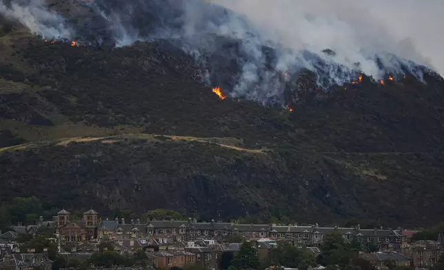 View of flames and smoke from a fire on Arthur's Seat in Holyrood Park, Edinburgh, Scotland, Sunday Aug. 10, 2025. (Jane Barlow/PA via AP)