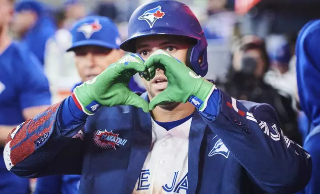 Toronto Blue Jays' George Springer (4) celebrates in the dugout after hitting a solo home run against the Minnesota Twins during fifth inning MLB baseball action in Toronto, on Tuesday, Aug. 26, 2025. (Sammy Kogan/The Canadian Press via AP)