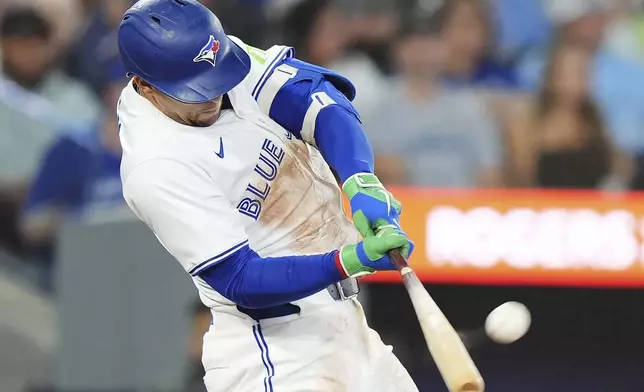 Toronto Blue Jays' George Springer hits a solo home run against the Minnesota Twins during the second inning of a baseball game in Toronto on Tuesday, Aug. 26, 2025. (Frank Gunn/The Canadian Press via AP)