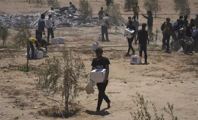Palestinians collect humanitarian aid packages from the United Arab Emirates after they were airdropped into Deir al-Balah, in central Gaza Strip, Tuesday, Aug. 5, 2025. (AP Photo/Abdel Kareem Hana)