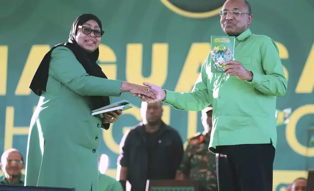 Tanzania's President Samia Suluhu Hassan, the presidential candidate of the ruling Chama Cha Mapinduzi (CCM) party, shakes hands with the President of Zanzibar, Dr. Hussein Ali Mwinyi, during the launch of the party's campaign for the upcoming general elections, at Tanganyika Packers grounds in Dar es Salaam, Tanzania, Thursday, Aug. 28, 2025. (AP Photo/Steven Genya)