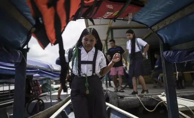 Students board Salvador Mitidieri's boat in Tabatinga, Brazil, to commute to school in Santa Rosa, Peru, Monday, Aug. 18, 2025. (AP Photo/Ivan Valencia)