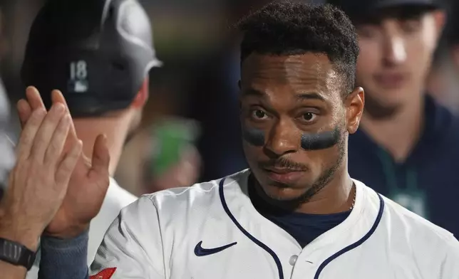 Seattle Mariners' Jorge Polanco is greeted in the dugout after scoring on a two-run single from J.P. Crawford against the San Diego Padres during the fifth inning of a baseball game Monday, Aug. 25, 2025, in Seattle. (AP Photo/Lindsey Wasson)