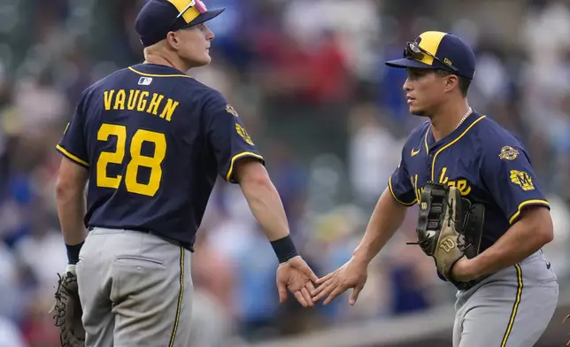 Milwaukee Brewers' Joey Ortiz, right, and Andrew Vaughn (28) celebrate after their team's win over the Chicago Cubs in the first baseball game of a split doubleheader Monday, Aug. 18, 2025, in Chicago. (AP Photo/Erin Hooley)