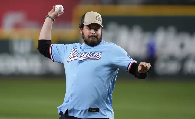 Actor Cole Hauser throws the ceremonial first pitch before a baseball game between the Cleveland Guardians and Texas Rangers Sunday, Aug. 24, 2025, in Arlington, Texas. (AP Photo/Tony Gutierrez)