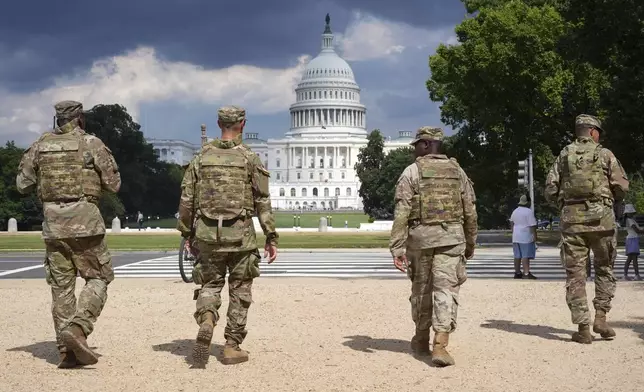 District of Columbia National Guard soldiers patrol on the National Mall, Thursday, August 14, 2025, in Washington. The U.S. Capitol is seen in the distance. (AP Photo/Jacquelyn Martin)