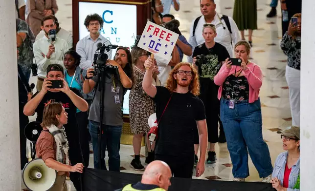 Demonstrators chant as White House Deputy Chief of Staff Stephen Miller, right, Defense Secretary Pete Hegseth and Vice President JD Vance, greet members of the National Guard, at Union Station in Washington, Wednesday, Aug. 20, 2025. (Al Drago/Pool via AP)